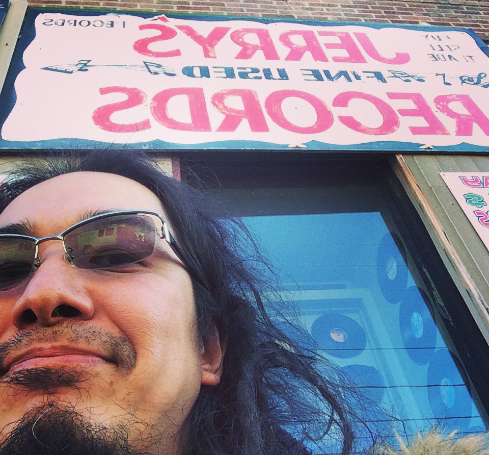 a selfie of suzuki junzo standing in front of a record shop